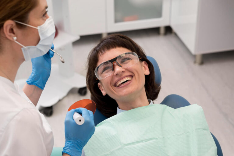 Dentista sorridente auxiliando paciente na escolha da cor para lentes de porcelana slim na Mooca, garantindo naturalidade e translucidez.